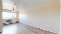 Located at 18645 Detroit Ave in Lakewood, Ohio, this single-floor unit offers a clean, functional layout with consistent light wood-style laminate flooring throughout, creating a cohesive and easy-to-maintain living environment. The living area is bright and open, featuring neutral cream-toned walls, white baseboards, and a ceiling fan with integrated lighting. A textured ceiling adds subtle architectural character, while a window allows natural light to filter into the space. Baseboard heating is present along the perimeter walls. The kitchen is a standout feature, outfitted with crisp white shaker-style cabinetry, light granite-look countertops, a stainless steel sink, and black appliances including a refrigerator and electric range with overhead ventilation. Ample upper and lower cabinet storage makes the kitchen highly practical. A secondary room offers generous wall space and the same wood-style flooring, suitable for use as a bedroom or flexible living space. The bathroom is neatly appointed with a full tub and shower surround, a white vanity, and a distinctive mosaic tile floor in warm neutral tones. The overall aesthetic throughout the unit is clean, bright, and move-in ready, with updated finishes that provide a comfortable and functional living space in the heart of Lakewood.