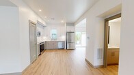 Located at 7201 McKnight Rd in Pittsburgh's 15237 zip code, this two-story unit is thoughtfully designed with a clean, modern aesthetic across both floors. The main level offers a generous footprint housing the kitchen and open living areas, while the upper level provides a slightly more intimate layout ideal for private spaces.

The kitchen is a standout feature, outfitted with two-tone cabinetry—white upper cabinets paired with gray lower cabinets—complemented by a white subway tile backsplash, quartz countertops, and a full suite of stainless steel appliances including a range, over-the-range microwave, dishwasher, and refrigerator. Light wood-look flooring flows seamlessly throughout, adding warmth to the bright, white interior.

Living areas are bathed in natural light through large windows that frame outdoor views of the surrounding Pittsburgh neighborhood. Bedrooms are well-proportioned, with ceiling fans, ample natural light, and access to a well-organized walk-in closet featuring built-in shelving and a drawer unit. The bathroom is clean and contemporary, featuring a gray vanity, white countertop, and a tub-shower combination with a curved rod. Recessed lighting throughout enhances the space's bright, modern ambiance.