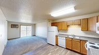 This single-floor residential unit offers a functional and comfortable layout designed to maximize everyday living. The open-concept kitchen and living area form the heart of the unit, where warm oak cabinetry, granite-style countertops, and white appliances — including a refrigerator, dishwasher, electric range, and microwave — provide a fully equipped cooking space. Wood-look vinyl flooring runs throughout the kitchen and main hallway areas, while plush carpeting defines the living room and bedrooms.

The spacious living room is bright and welcoming, featuring a sliding glass door that opens to a private balcony, a wall-mounted air conditioning unit, and a baseboard heating system. Textured ceilings are found throughout the unit, adding a classic residential character.

The bedrooms are well-sized, each with carpeted floors and natural light from windows. Sliding wood-panel closet doors provide generous storage. The bathroom is neatly appointed with warm oak vanity cabinetry, granite-style countertops, a large mirror with overhead lighting, and access to a separate shower area.

A dedicated laundry area accommodates a full-size washer and dryer, adding exceptional in-unit convenience. Additional closet space and ample storage options round out this practical and comfortable living space.