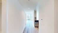 This contemporary 710 square foot apartment in San Francisco offers a harmonious blend of style and functionality. The open-concept living area is anchored by a sleek, U-shaped kitchen featuring dark wood cabinetry, stainless steel appliances, and a multi-toned tile backsplash. The space flows seamlessly into the living room, where floor-to-ceiling windows flood the area with natural light and provide stunning panoramic views of the city skyline.

The bedroom, measuring 180 square feet, offers ample space and includes a walk-in closet with a customizable shelving system. The bathroom showcases a modern aesthetic with a floating vanity, large mirror, and a glass-enclosed shower. Light wood-look flooring unifies the entire apartment, creating a warm and inviting atmosphere.

Additional amenities include an in-unit laundry area with a stacked washer and dryer, and extra storage space. The apartment's design maximizes every square foot, resulting in a highly efficient and comfortable living environment. Located at 388 Beale St in the heart of San Francisco, this urban oasis combines luxury and convenience in one of the city's most desirable neighborhoods.