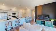 Located at 8000 Arlington Expy in Jacksonville, FL, this thoughtfully designed 2-bedroom, 2-bathroom residence offers a modern, single-floor layout with clean lines and a bright, neutral palette throughout. Light wood-look flooring flows seamlessly across all rooms, creating a cohesive and airy feel.

The welcoming entrance hallway leads past multiple closets toward the open-concept living, dining, and kitchen area. The kitchen is well-appointed with white shaker cabinetry, stainless steel appliances, a double sink, and a breakfast bar with seating — ideal for casual dining. The living area features a striking dark accent wall with vertical wood slat detailing, providing a bold focal point, while expansive floor-to-ceiling windows flood the space with natural light and offer open exterior views.

Both bedrooms are comfortably sized, each featuring large black-framed windows that bring in ample sunlight. The primary bedroom includes dedicated closet space and a ceiling fan. The two bathrooms are clean and functional: one includes a long white vanity with ample cabinet storage, while the other offers a walk-in glass-enclosed shower, single vanity, and toilet. A dedicated laundry area and additional hallway closets round out the practical layout of this well-organized Jacksonville residence.