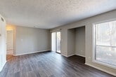 Located at 2325 Woodcrest Walk in Lithonia, GA, this one-bedroom, one-bathroom home offers a well-designed single-level layout with a cohesive, modern aesthetic throughout. The open living area is finished with rich, dark-toned hardwood-style flooring and a textured ceiling, lending warmth and character to the space. Sliding glass doors with vertical blinds open to a private balcony, filling the room with natural light and offering outdoor views.

The kitchen is a standout feature, boasting dark espresso cabinetry, granite-style countertops, a mosaic tile backsplash, and a full suite of stainless steel appliances. A peninsula with an undermount sink connects the kitchen to the living area, creating an efficient and stylish open-concept flow.

The bedroom is comfortably sized, finished with plush carpeting, a ceiling fan, and a window with blinds that allows for natural light. A dedicated closet provides convenient storage, and the room connects directly to the hallway leading to the full bathroom. The bathroom includes a tub-shower combination with clean white surround. Neutral gray tones are carried throughout the home, creating a calm and unified ambiance ideal for comfortable everyday living.