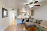Located at 815 Pomona Ave in Chico, CA, this single-story, 3-bedroom, 2-bathroom home offers a well-organized and functional layout across a comfortable footprint. The open-concept living and kitchen area serves as the heart of the home, featuring warm hardwood flooring and a ceiling fan overhead. The kitchen is outfitted with light wood cabinetry, tile countertops, a breakfast bar with seating for two, and standard appliances including a dishwasher and range. The living room flows naturally from the kitchen and includes a sliding glass door that opens directly to the outdoors, filling the space with natural light. A long hallway connects the common areas to the private rooms at the rear of the home. The three bedrooms are carpeted and each features a ceiling fan and windows with views of the surrounding greenery. The primary bedroom offers a generous amount of space. A dedicated office provides additional versatility. The two bathrooms include light wood vanities and tiled flooring, with one featuring a shower-tub combination and a window for natural ventilation. A closet provides added storage. The home presents a clean, neutral palette throughout, creating a bright and livable environment.