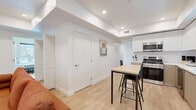 Located at 626 N Wilton Place in Los Angeles, CA, this modern unit offers six bedrooms and six bathrooms across a single, well-organized floor. The open-concept kitchen is a standout feature, showcasing two-tone cabinetry in white and warm taupe, a full suite of stainless steel appliances including a large French door refrigerator, microwave, gas range, and dishwasher, all complemented by white quartz countertops and light wood flooring. A compact dining table with bar-height seating bridges the kitchen and living area seamlessly. Each of the six bedrooms is bright and minimalist, featuring white walls, light wood flooring, and individual smart lock entry doors for added privacy and security. Natural light filters into the bedrooms through windows, creating a clean and comfortable atmosphere. The six bathrooms follow a consistent, modern aesthetic with all-white tile, white quartz vanities with under-mount sinks, sleek floating cabinetry, and tub-shower combinations with chrome fixtures. Recessed lighting throughout the unit enhances the bright, contemporary feel. A central hallway connects all rooms efficiently, making the layout functional for multiple occupants. The overall design is clean, cohesive, and well-suited for shared living in the heart of Los Angeles.