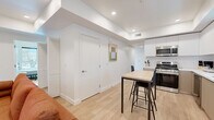 Located at 626 N Wilton Place in Los Angeles, CA, this modern unit offers six bedrooms and six bathrooms across a single, well-organized floor. The open-concept kitchen is a standout feature, showcasing two-tone cabinetry in white and warm taupe, a full suite of stainless steel appliances including a large French door refrigerator, microwave, gas range, and dishwasher, all complemented by white quartz countertops and light wood flooring. A compact dining table with bar-height seating bridges the kitchen and living area seamlessly. Each of the six bedrooms is bright and minimalist, featuring white walls, light wood flooring, and individual smart lock entry doors for added privacy and security. Natural light filters into the bedrooms through windows, creating a clean and comfortable atmosphere. The six bathrooms follow a consistent, modern aesthetic with all-white tile, white quartz vanities with under-mount sinks, sleek floating cabinetry, and tub-shower combinations with chrome fixtures. Recessed lighting throughout the unit enhances the bright, contemporary feel. A central hallway connects all rooms efficiently, making the layout functional for multiple occupants. The overall design is clean, cohesive, and well-suited for shared living in the heart of Los Angeles.
