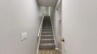 Located at 5327 Timuquana Rd in Jacksonville, Florida, this two-story, 2-bedroom, 2-bathroom home is thoughtfully laid out across two evenly sized floors. The main level features light wood-style flooring throughout the living and kitchen areas, creating a clean, cohesive aesthetic. The kitchen is well-appointed with white cabinetry, a mosaic tile backsplash, light stone countertops, and stainless steel appliances including a refrigerator, range, and dishwasher. A sliding glass door in the main living area fills the space with natural light and provides outdoor access. A carpeted staircase with a white railing leads to the upper level, where both bedrooms are located. Each bedroom features plush carpet flooring, neutral gray walls, ceiling fans, and windows with blinds that allow for natural light and ventilation. The spacious primary bedroom offers generous room dimensions. Both bathrooms are clean and functional, featuring tub-shower combinations with tiled surrounds. Multiple closets provide ample storage throughout the home. The neutral color palette and consistent finishes across both floors give the space a unified and move-in-ready feel.