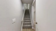 Located at 5327 Timuquana Rd in Jacksonville, Florida, this two-story, 2-bedroom, 2-bathroom home is thoughtfully laid out across two evenly sized floors. The main level features light wood-style flooring throughout the living and kitchen areas, creating a clean, cohesive aesthetic. The kitchen is well-appointed with white cabinetry, a mosaic tile backsplash, light stone countertops, and stainless steel appliances including a refrigerator, range, and dishwasher. A sliding glass door in the main living area fills the space with natural light and provides outdoor access. A carpeted staircase with a white railing leads to the upper level, where both bedrooms are located. Each bedroom features plush carpet flooring, neutral gray walls, ceiling fans, and windows with blinds that allow for natural light and ventilation. The spacious primary bedroom offers generous room dimensions. Both bathrooms are clean and functional, featuring tub-shower combinations with tiled surrounds. Multiple closets provide ample storage throughout the home. The neutral color palette and consistent finishes across both floors give the space a unified and move-in-ready feel.