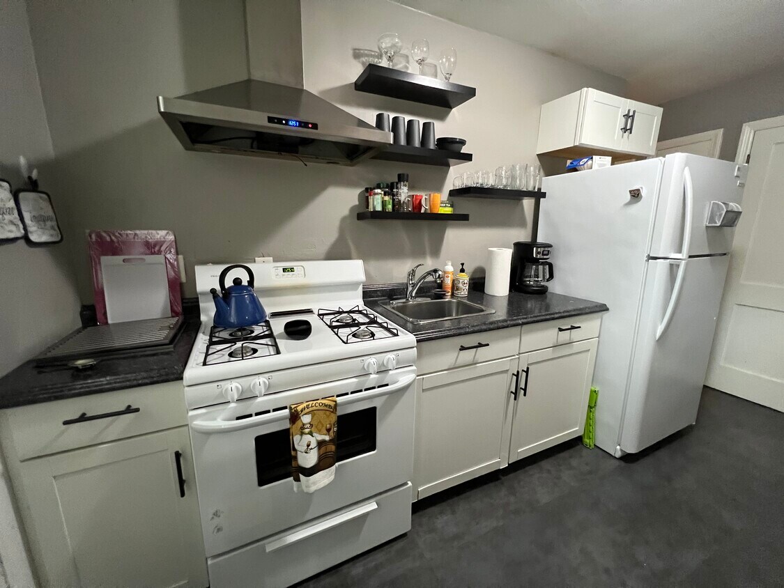 Cocina completa con cafetera, ollas, sartenes, microondas, tostadora y vajilla. - 4622 Cass St