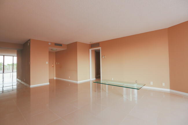 Living room looking toward front door and primary bedroom. - 1000 Quayside Ter