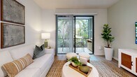 Located in Wellington, FL, this thoughtfully designed two-bedroom, two-bathroom residence offers a bright, modern living experience across a single floor. The open-concept kitchen and living area serves as the heart of the home, featuring sleek white flat-panel cabinetry extending to the ceiling, stainless steel appliances, a crisp white quartz island with bar seating, and elegant pendant lighting. Light wood-look flooring flows seamlessly throughout, enhancing the airy, cohesive aesthetic. The living area opens directly to a private patio through sliding glass doors, offering lush greenery views and filling the space with natural light. The generously sized primary bedroom includes a ceiling fan, large windows overlooking greenery, and ample closet space. The second bedroom mirrors this comfortable, light-filled quality. Both bathrooms are finished in clean white tile; one features a wood-toned vanity with a white quartz countertop and a walk-in shower, while the other includes a tub-shower combination. A dedicated in-unit laundry room with side-by-side washer and dryer adds everyday convenience. Four closets provide exceptional storage throughout. The overall ambiance is clean, contemporary, and inviting — ideal for comfortable Florida living.