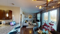 This thoughtfully designed single-floor residence offers a cohesive blend of contemporary style and functional living across its well-organized layout. The open-concept living and dining area serves as the heart of the home, anchored by rich hardwood flooring, a statement sputnik-style chandelier above the dining space, and large windows and sliding glass doors that fill the room with natural light while offering outdoor views. A round gold-framed mirror and curated wall art add character to the living area, which features a neutral sectional sofa accented with bold teal and mustard pillows.

The kitchen is outfitted with dark espresso cabinetry, granite countertops, and a full suite of stainless steel appliances, including a refrigerator, range, and built-in microwave. A granite-topped breakfast bar provides additional seating and workspace.

The primary bedroom is a serene retreat, complete with plush carpeting, a walk-in closet with built-in shelving, and an en-suite bathroom featuring a granite vanity, tile flooring, and direct walk-in closet access. The second bedroom offers equally comfortable accommodations with natural light and stylish décor. A second full bathroom includes a combination tub and shower with granite countertops, maintaining the home's consistent design aesthetic throughout.