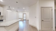 Located in Bradenton, FL, this thoughtfully designed one-bedroom, one-bathroom residence offers a clean, modern aesthetic throughout its single-story layout. The open-concept living and dining area flows seamlessly from the kitchen, featuring light wood-look flooring, recessed lighting, and a private entry door that fills the space with natural light through window blinds.

The kitchen is a standout feature, showcasing white shaker cabinetry, granite countertops, a subway tile backsplash, and a full suite of stainless steel appliances including a French door refrigerator, range, and microwave. A large granite-topped island with pendant lighting serves as a functional centerpiece ideal for dining or entertaining.

The generously sized bedroom is finished with plush carpeting, a ceiling fan, and a bright window. It connects to a walk-in closet equipped with wire shelving systems, offering ample storage. The bathroom features a soaking tub with a tiled shower surround, granite vanity countertop, and wood-look flooring that complements the rest of the home.

With its bright white walls, consistent finishes, and efficient use of space, this residence presents a polished and comfortable living environment in the Lakewood Ranch area of Bradenton.