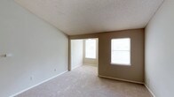This single-floor, 1-bedroom, 1-bathroom unit with a sunroom offers a thoughtfully designed layout that maximizes comfort and functionality. The living area features soft carpeting, neutral warm-toned walls, and a textured ceiling, creating a welcoming atmosphere. Vaulted ceilings in the living space add a sense of openness, and the area flows naturally into the dining room, which is accented by an elegant chandelier. Multiple windows throughout the unit allow abundant natural light to fill the space.

The galley-style kitchen is well-appointed with light wood cabinetry, white countertops, a double stainless steel sink, and wood-style flooring. It includes a full suite of appliances — electric range, refrigerator, built-in microwave, and dishwasher — along with ample overhead storage. A skylight-style ceiling fixture keeps the kitchen bright and functional.

The bedroom is generously sized, offering two windows, plush carpeting, and access to a walk-in closet with built-in shelving and hanging rods. The sunroom, featuring corner windows and a ceiling fan with light fixture, provides a bright, versatile bonus space ideal for relaxing or a home office. Overall, the unit presents a practical and comfortable living environment.