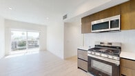 Located on the fifth floor at 1333 Tamarind Ave in the heart of Hollywood, Los Angeles, this modern 4-bedroom, 4-bathroom unit offers a thoughtfully designed layout with contemporary finishes throughout. Light wood flooring runs consistently across all rooms, creating a bright, cohesive aesthetic complemented by clean white walls and recessed lighting.

The kitchen is appointed with warm wood-toned cabinetry, stainless steel appliances including a gas range, built-in microwave, refrigerator, and dishwasher, along with a geometric tile backsplash and clean white countertops. Each of the four bedrooms is well-proportioned, with the primary bedroom offering a generous footprint, a sliding mirrored closet door, and access to natural light. Several bedrooms feature windows with views of the surrounding Los Angeles cityscape.

Each of the four bathrooms is finished with floor-to-ceiling tiled walk-in showers enclosed by frameless glass doors, floating wood vanities with white countertops, and neutral tilework, reflecting a consistent modern sensibility. The unit's overall design emphasizes clean lines, neutral tones, and functional efficiency, making it a well-appointed residence in a vibrant Los Angeles neighborhood.