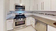 Located at 39 Constantine Pl in Summit, NJ, this single-floor residence offers a well-designed layout that balances classic architectural details with modern updates. Rich hardwood flooring flows throughout the main living areas, complementing the neutral, light-toned walls that create a clean and inviting atmosphere.

The living and dining areas feature crown molding and flush-mount lighting, with the dining space highlighted by an elegant chandelier. Natural light enters through multiple windows fitted with blinds, offering views of the surrounding mature trees and greenery. Radiator heating units are present throughout, reflecting the home's classic construction.

The kitchen has been thoughtfully updated with white shaker-style cabinetry, stainless steel appliances including a gas range, over-the-range microwave, and dishwasher, along with a mosaic tile backsplash and durable countertops. Light tile flooring completes the space.

The bedroom features dual closets for ample storage and a window overlooking the lush tree canopy outside. The bathroom is finished with wood-look tile flooring, a white vanity, and a window that allows natural light to fill the space. Overall, the residence presents a comfortable and well-maintained living environment in a desirable Summit location.