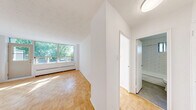 Located at 4750 Bathurst Street in Toronto's North York neighbourhood, this well-appointed one-bedroom, one-bathroom unit offers a thoughtfully organized layout across a single floor. The space is composed of a bedroom, living room, kitchen, bathroom, and hallway, making efficient use of every square foot.

The kitchen has been tastefully renovated and features white shaker-style cabinetry, dark countertops, classic white subway tile backsplash, and a full suite of stainless steel appliances including a refrigerator, electric range with oven, built-in microwave, and dishwasher. A window above the range allows natural light to filter in.

The generously sized primary bedroom is bathed in natural light through a wide multi-pane window overlooking mature trees. Warm parquet hardwood flooring runs throughout the bedroom and living areas, lending a timeless character to the space. The bedroom also features a built-in sliding door closet for practical storage.

The bathroom is finished with clean white subway tile surrounding a full soaking tub with shower, creating a bright and crisp aesthetic. A small window provides natural ventilation.

A private balcony extends the living space outdoors, offering pleasant views of tree-lined green space and the surrounding neighbourhood under open skies — a serene retreat in the heart of Toronto.
