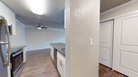 This single-floor residence in Alameda, CA (94501) offers a well-organized layout that connects the kitchen and living area in an open, functional arrangement. The kitchen is equipped with stainless steel appliances, including a refrigerator, electric range, and microwave, complemented by white cabinetry with brushed nickel hardware and a dark countertop that extends to a peninsula with an integrated sink. Wood-style flooring runs throughout the main living areas, adding warmth and cohesion to the space.

The spacious living room benefits from crown molding, a ceiling fan, and a textured ceiling, while a sliding glass door opens to a private balcony that overlooks greenery, bringing natural light into the interior. The bedroom is carpeted for comfort and features a large window with views of surrounding trees, along with a baseboard heater and a closet. The bathroom includes a vanity with dark countertop, white cabinetry, and a shower-tub combination. Textured walls are present throughout, contributing to the unit's consistent aesthetic. Overall, the space presents a clean, move-in-ready environment suited for practical, comfortable living.