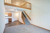 Located at 9222 Waterside St in Madison, WI, this 3-bedroom, 2-bathroom single-floor home offers a well-designed layout with a mix of comfort and functionality. The living area is anchored by striking vaulted ceilings that lend an open, airy feel, with carpet flooring and a sliding glass door that floods the space with natural light and provides access to the outdoors.

The kitchen is a central highlight, featuring white cabinetry, a peninsula island with a countertop overhang, hardwood-style flooring, and track lighting overhead. White appliances — including a range, microwave, dishwasher, and refrigerator — complement the clean, bright aesthetic. The kitchen flows naturally into the main living area, making it ideal for everyday living.

Each bedroom is carpeted and equipped with a ceiling fan. The bedrooms feature generous closet space with built-in shelving and offer views of the surrounding autumn foliage through large windows. The primary bedroom is particularly spacious, with dual windows framing picturesque outdoor scenery.

The two bathrooms are clean and functional. One includes a framed glass walk-in shower with wood-tone flooring, while the other features a full tub-shower combination with a curved curtain rod and grab bars for added convenience. Warm wood-toned trim and doors throughout the home tie the interior together with a cohesive, welcoming feel.