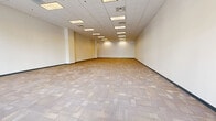 Located at 5301 Alpha Rd, Suite B36, in Dallas, TX, this single-floor commercial space offers a generous and versatile layout well-suited for a variety of business uses. The main area is expansive and open, providing significant flexibility for configuration. Neutral-toned patterned carpet tiles cover the floors throughout, complementing the clean, white walls and creating a professional atmosphere. The drop-panel ceiling features a grid of recessed fluorescent lighting that ensures consistent, even illumination across the entire floor plate. A standout architectural feature is the large storefront window wall at the front of the suite, which floods the space with natural light and provides clear visibility to the exterior, enhancing the presence and accessibility of the suite. Toward the rear, a corridor leads to the supporting spaces, including two bathrooms, a dedicated private office, and a closet — providing practical amenities for daily operations. The overall design is clean and functional, with neutral finishes that offer a blank canvas ready for tenant customization. The suite's open floor plan, combined with its support rooms and prominent street-facing windows, makes it a practical and highly adaptable commercial space.