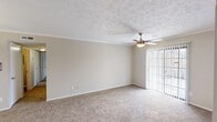Located at 7028 Watchman Cir in Montgomery, Alabama, this single-story home offers a well-organized layout with a neutral color palette and consistent finishes throughout. The living room is generously proportioned, featuring plush carpeting, crown molding, a textured ceiling, and a ceiling fan with integrated lighting. Vertical blinds frame a sliding glass door that opens to the outdoors, allowing natural light to fill the space.

Adjacent to the living room, a dining area is defined by chair rail molding and a pendant light fixture overhead, creating a distinct yet open transition between entertaining spaces. A passthrough connects to the galley-style kitchen, which features white upper cabinetry, gray lower cabinetry, light countertops, a stainless steel refrigerator, and wood-look flooring that adds warmth and easy maintenance.

The bedrooms are carpeted and finished with textured ceilings. One bedroom includes a large window for natural light and a double sliding-door closet providing generous storage. Both bathrooms are updated with gray vanity cabinetry, light countertops, large mirrors, and wood-look flooring. One bathroom includes a shower-tub combination, while the other features a single vanity with brushed nickel hardware.
