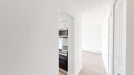 Located at 5815 Yew St in Vancouver's desirable Kerrisdale neighbourhood, this well-designed one-bedroom, one-bathroom unit offers a clean, modern aesthetic throughout. Light-toned laminate flooring flows seamlessly across the entire floor plan, complementing the bright white walls and creating a cohesive, airy atmosphere.

The open-concept kitchen and living area serves as the heart of the unit. The kitchen is thoughtfully appointed with white shaker-style cabinetry, grey quartz countertops, a light blue subway tile backsplash, stainless steel appliances — including a French door refrigerator, electric range, and built-in microwave — and a peninsula island that doubles as a breakfast bar. The spacious living room is flooded with natural light through expansive floor-to-ceiling sliding glass doors that open to a balcony, offering pleasant treetop and neighbourhood views.

The bedroom is a comfortable and well-proportioned retreat, featuring a large window that frames outdoor views and a mirrored sliding door closet. Baseboard heating is present throughout the unit.

The bathroom is finished with warm-toned ceramic tile flooring, a dark wood vanity with a white countertop and integrated sink, and a tiled shower and tub surround, offering a clean and functional design. Overall, this unit presents a bright, modern, and efficiently laid-out living space.