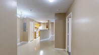 Located at 616 Highway 90 in Waveland, Mississippi, this single-floor unit offers a well-organized layout with three bedrooms, two bathrooms, and a dedicated laundry room. The galley-style kitchen features warm honey-toned cabinetry, granite-look countertops, a double basin sink, and white appliances including an electric range and dishwasher — efficiently designed to maximize functionality. The living area is bright and open, highlighted by a ceiling fan with light fixture and French doors that bring in natural light and provide access to a covered porch overlooking the community grounds. Neutral tan walls and light-toned flooring carry consistently throughout the main living areas, lending a cohesive, clean aesthetic. The primary bedroom is a comfortable size and includes direct access to a private en-suite bathroom, which features a wood-toned vanity with granite-look counters. The secondary bedrooms are carpeted and receive natural light through slatted windows. A second full bathroom with a tub/shower combo serves the remaining rooms. The dedicated laundry room accommodates a full-size washer and includes overhead shelving for additional storage. Two closets provide further organization throughout the unit. A private porch entry completes this practical and well-appointed home.