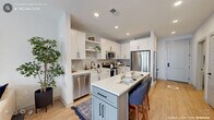 Located at 330 Towerview Court in Cary, NC, this one-bedroom residence offers a well-designed single-floor layout that maximizes both function and style. The open-concept kitchen is a standout feature, showcasing white shaker cabinetry with matte black hardware, a subway tile backsplash, stainless steel appliances, and a two-tone center island with quartz countertops and bar seating — ideal for casual dining and entertaining. Light hardwood flooring runs throughout the main living areas, complementing the clean, contemporary aesthetic. The living room is bright and inviting, featuring large windows that flood the space with natural light and a glass door that opens directly to a private balcony, extending the living space outdoors. The bedroom is a comfortable retreat, finished with plush carpet, a ceiling fan, and a generous window. It connects to a dedicated closet equipped with full-length hanging rods and shelving, with a stacked washer and dryer conveniently located within. Recessed lighting throughout and a neutral color palette tie the entire space together, creating a cohesive and modern atmosphere well-suited for everyday living in the heart of Cary.