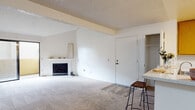 Located on Calle Verde in La Mesa, California, this single-story residence offers a well-organized and functional layout throughout. The living room serves as the central gathering space, featuring a brick-surround fireplace, soft carpeting, and vaulted ceilings that lend a sense of openness. A sliding glass door leads to an outdoor balcony, allowing natural light to fill the room and providing easy access to the exterior.

The kitchen is outfitted with warm wood-toned cabinetry offering generous storage, a white appliance suite including a refrigerator and electric range, and light wood-style flooring. A peninsula with a light stone-finish countertop and bar seating creates a natural connection between the kitchen and the adjacent living area. A closet for additional storage is conveniently positioned nearby.

The bedrooms are carpeted and bright, with large windows that invite natural light. One bedroom features a mirrored sliding-door closet with built-in shelving, while another includes a dedicated vanity area with warm wood cabinetry, a wide mirror, and countertop space. The bathroom is fitted with a full vanity, stone-finish countertop, and a shower-tub combination. Textured ceilings are consistent throughout the home, complementing the neutral, light color palette.