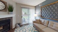 Located at 1555 Saddle Brook Lane in Westlake, Ohio, this single-floor residence offers a well-appointed layout with a cohesive, contemporary aesthetic throughout. The living area serves as a welcoming central space, featuring wood-look flooring, a sliding glass door that opens to an outdoor patio with greenery views, and a distinctive accent wall in muted blue-grey that adds depth and character. A decorative geometric wall piece and tufted sofa contribute to the room's polished, modern feel.

The galley-style kitchen is efficiently designed with rich dark cabinetry, light marble-look countertops, subway tile backsplash, and stainless steel appliances. A hallway connects the kitchen to additional utility areas, enhancing the functional flow of the space.

The bedrooms are carpeted and well-lit, each receiving natural light through blinded windows. Textured ceilings and neutral wall tones create a calm, restful atmosphere, while thoughtful décor details such as wood-framed headboards and layered bedding add warmth. One bedroom includes access to a walk-in closet.

The bathroom is finished with wood-look flooring, dark wood vanity cabinetry, a white countertop, and a large mirror, giving it a clean and contemporary look. Overall, the residence presents a comfortable and cohesive living environment.