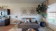 This two-story residence in Pullman, Washington offers a well-designed layout distributed across two levels. The main floor centers around an open-concept kitchen and living area, where wood-style flooring flows throughout. The kitchen is a standout feature, equipped with dark espresso cabinetry, granite countertops, stainless steel appliances, and a large island with bar seating. Pendant lighting adds a modern touch overhead, while a sliding glass door provides direct access to the outdoors and fills the space with natural light. The adjacent living area is comfortably sized, featuring a front-facing window and a staircase leading to the upper level.

Upstairs, the bedrooms are carpeted and offer a quiet retreat from the main living areas. Each room provides adequate space for sleeping and study areas, with windows that allow natural light in. The second floor also features a full bathroom with a dark wood vanity, granite countertop, and a shower-tub combination. A second full bathroom of similar design is also present within the unit. Both bathrooms are finished with tile flooring and well-lit vanity mirrors. Overall, the residence presents a clean, contemporary aesthetic suited for comfortable everyday living.