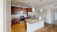 Located at 250 District Dr in Asheville, NC, this single-floor, three-bedroom, two-bathroom residence offers a well-designed layout across a generously sized floor plan. The open-concept kitchen and living area serves as the heart of the home, featuring rich dark-wood cabinetry, granite countertops, a center island with a undermount sink, stainless steel appliances, a subway tile backsplash, and track lighting accented by pendant lights — all set atop warm wood-style flooring. A dedicated pantry and in-unit laundry add to the home's practicality.

The three bedrooms are carpeted for comfort and include ceiling fans and windows that bring in natural light with views of the surrounding community. The spacious primary bedroom connects directly to an en-suite bathroom equipped with a dual-sink granite vanity, rich wood cabinetry, a glass-enclosed walk-in shower, and wood-style flooring. A walk-in closet with wire shelving provides ample storage. The second bathroom features a tiled tub-shower combination, a granite-topped vanity, and coordinating finishes. Throughout the home, seven closets ensure exceptional storage, and clean white walls with bright trim contribute to a fresh, modern aesthetic.