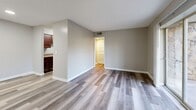 Located at 203 Sealey Dr in Madison, Tennessee, this one-bedroom, two-bathroom residence offers a thoughtfully organized single-floor layout designed to maximize every square foot. The open-concept living and dining area is a central highlight, featuring wood-look laminate flooring in a neutral gray tone that flows seamlessly throughout the main living spaces. A sliding glass door leads directly to a private patio, filling the room with natural light and offering pleasant outdoor views of surrounding greenery.

The kitchen is positioned adjacent to the living area and features rich dark wood cabinetry paired with granite-look countertops and black appliances, providing a functional and attractive cooking space. A hallway connects the main living area to the private bedroom, which is generously sized and finished with plush carpeting and a window overlooking the outdoors. Two closets offer ample storage throughout the unit.

Both bathrooms are clean and functional. One features a full soaking tub and shower combination with wood-look flooring, while the other includes a wide vanity with dark wood cabinetry and stone-look countertops topped by a large mirror. A dedicated utility room and additional storage areas round out the practical amenities of this well-appointed residence.