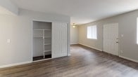 This single-floor unit offers a well-organized layout that balances open living areas with comfortable private spaces. The living room welcomes residents with durable hardwood-style flooring, neutral gray walls, and a large window that fills the space with natural light. A front entry door provides direct access, and a built-in shelving unit with sliding panel doors offers generous storage.

The kitchen is efficiently designed with white shaker-style cabinetry, brushed nickel hardware, white countertops, a stainless steel double-basin sink, and under-cabinet lighting. Stainless steel appliances, including a range and dishwasher, complete the space. The hardwood-style flooring continues through the kitchen, maintaining a cohesive look.

The bedrooms are carpeted for comfort and feature neutral tones, vertical blinds, and windows that bring in outdoor views and natural light. The rooms offer a clean, versatile canvas suitable for a variety of furniture arrangements.

The bathroom is finished with white square tile surrounding the tub and shower combo, accented by brushed nickel fixtures including a showerhead and towel bar. The vanity provides countertop space alongside the toilet, while hardwood-style flooring ties the room together. Throughout the unit, a consistent neutral color palette and clean finishes create a bright, move-in-ready atmosphere.