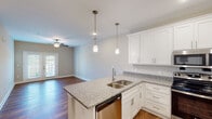 Located at 4650 Crescent Pointe Dr in North Charleston, SC, this single-floor residence offers a well-designed, open layout with a cohesive blend of modern finishes and comfortable living spaces. The kitchen serves as a central highlight, featuring white shaker-style cabinetry, granite countertops, a peninsula with an undermount sink, pendant lighting, and a full suite of stainless steel appliances including a range, microwave, dishwasher, and refrigerator. Warm hardwood flooring extends throughout the main living areas, complementing the neutral, light-toned walls that lend the space a clean and airy feel. The living area is bright and open, anchored by a ceiling fan and French doors that invite natural light while providing access to an outdoor space. The bedrooms are carpeted for comfort, each equipped with ceiling fans and windows fitted with blinds that frame views of the surrounding landscape. The bathrooms are finished with granite-top vanities, white cabinetry, and hardwood-style flooring, with one bathroom featuring a full tub-shower combination. A hallway connects the private areas of the home seamlessly, reinforcing the functional and thoughtfully arranged single-level floor plan.