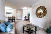 This single-floor residence offers a thoughtfully designed layout that balances comfort and functionality. The living room features elegant crown molding, plush carpeting, and large windows with blinds that fill the space with natural light, creating a warm and inviting atmosphere. Adjacent to the living area is a cozy dining nook, accented by decorative crown molding and tile flooring, providing a smooth transition between the living and kitchen spaces.

The kitchen is well-equipped with warm wood cabinetry, granite countertops, black appliances, and a breakfast bar that doubles as additional dining space. Tile flooring runs throughout, adding a clean, practical finish.

The primary bedroom is generously sized with carpet flooring, a window with natural views, and direct access to a private en-suite bathroom. The en-suite features a granite-topped vanity with rich wood cabinetry and a full tub-shower combination. Two additional bedrooms offer comfortable accommodations with plush carpeting and ample natural light. A second full bathroom includes a tiled tub-shower combination, providing convenience for residents and guests alike. Throughout the home, neutral tones and consistent finishes create a cohesive and livable environment.