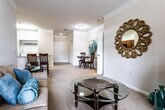 This single-floor residence offers a thoughtfully designed layout that balances comfort and functionality. The living room features elegant crown molding, plush carpeting, and large windows with blinds that fill the space with natural light, creating a warm and inviting atmosphere. Adjacent to the living area is a cozy dining nook, accented by decorative crown molding and tile flooring, providing a smooth transition between the living and kitchen spaces.

The kitchen is well-equipped with warm wood cabinetry, granite countertops, black appliances, and a breakfast bar that doubles as additional dining space. Tile flooring runs throughout, adding a clean, practical finish.

The primary bedroom is generously sized with carpet flooring, a window with natural views, and direct access to a private en-suite bathroom. The en-suite features a granite-topped vanity with rich wood cabinetry and a full tub-shower combination. Two additional bedrooms offer comfortable accommodations with plush carpeting and ample natural light. A second full bathroom includes a tiled tub-shower combination, providing convenience for residents and guests alike. Throughout the home, neutral tones and consistent finishes create a cohesive and livable environment.