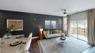 Located in the heart of Charlotte's West Fourth Street corridor, this single-floor residence offers a thoughtfully designed layout with modern finishes throughout. The kitchen is equipped with dark espresso cabinetry, granite-style countertops, a white tile backsplash, and a full suite of stainless steel appliances, including a range, microwave, and French door refrigerator. Durable wood-style flooring runs through the main living areas, adding warmth and continuity.

The living room is a standout space, anchored by a bold dark accent wall, ceiling fan, and large windows and a sliding glass door that open to a private balcony with outdoor views — flooding the room with natural light. A dedicated dining area completes the open-concept living zone.

The primary bedroom features a calming blue accent wall, ceiling fan, and generous windows overlooking the exterior. A secondary bedroom also benefits from abundant natural light through large multi-pane windows. Both bedrooms are supported by well-appointed bathrooms — a full bath with a dark vanity, granite countertop, and shower/tub combo, plus a half bath with matching finishes and tile flooring. The overall ambiance is modern and comfortable, ideal for urban living in Charlotte.