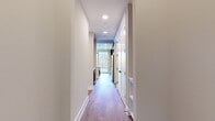 This 940 square foot urban apartment offers a thoughtful layout maximizing space and functionality. The single-floor plan includes one bedroom measuring 130 square feet, complemented by two full bathrooms for added convenience. The heart of the home features an open concept design, seamlessly blending two living room areas with the kitchen, creating a spacious feel ideal for entertaining or relaxation.

Large windows dominate one wall, flooding the interior with natural light and providing stunning views of the surrounding cityscape. The wood-look flooring adds warmth and durability throughout, contrasting nicely with the neutral-toned walls. High ceilings enhance the sense of spaciousness, while recessed lighting offers versatile illumination options.

Two hallways provide easy navigation through the apartment, leading to well-appointed closets for ample storage. The entrance area welcomes residents and guests alike, setting the tone for the modern urban lifestyle this apartment embodies. Perfect for singles or couples, this apartment balances comfort and style in a prime city location.