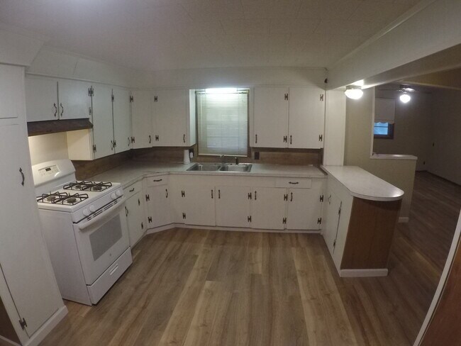 Kitchen includes refrigerator and gas range, utility hookups with lots of storage cabinets. - 5011 Mire Hwy
