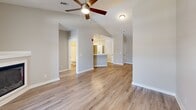 Located at 10480 Auto Mall Pkwy in D'Iberville, Mississippi, this two-story, one-bedroom, one-bathroom unit offers a thoughtfully designed layout across two levels. The ground floor houses an attached garage with automatic opener, providing secure and convenient parking or additional storage space.

The main living level showcases an open-concept kitchen and living room with light hardwood-style flooring and vaulted ceilings accented by a ceiling fan. The kitchen is well-appointed with white shaker-style cabinetry, stainless steel appliances including a refrigerator and range with microwave, crisp white countertops, a breakfast bar peninsula with pendant lighting, and recessed ceiling lights—creating a bright, functional cooking and dining space.

The spacious bedroom features plush carpet, a ceiling fan, and a window that allows natural light to fill the room. The bedroom connects to a dedicated closet and is situated near the full bathroom, which includes a tub-shower combo with built-in shelving, a white vanity, and wood-look tile flooring. Additional spaces include two hallways, a utility room, and staircases connecting the two floors, ensuring practical flow throughout the home. The neutral color palette and modern finishes give the space a clean, move-in-ready feel.
