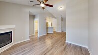 Located in D'Iberville, Mississippi, this two-story unit offers a thoughtful layout across two levels. The ground floor houses a private garage with an automatic opener, providing secure parking and additional storage space with a clean, well-lit interior.

The main living level features an open-concept kitchen and living area with light wood-look flooring and a ceiling fan. The kitchen is well-appointed with crisp white shaker-style cabinetry, a peninsula breakfast bar with pendant lighting, white quartz countertops, stainless steel appliances including a refrigerator and over-the-range microwave, and a gas range. Recessed lighting brightens the space, which flows seamlessly into the living area.

The bedroom is generously sized, carpeted for comfort, and includes a ceiling fan and windows that invite natural light. A dedicated closet provides ample storage. The full bathroom features a tub-shower combination with built-in shelving, a white vanity, and wood-look flooring throughout. A utility room and hallways round out the functional layout. Neutral warm-toned walls and consistent finishes throughout give the space a cohesive, modern aesthetic.