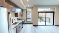 This 450 square foot apartment, located at 531 W Washington Ave in Madison, Wisconsin, showcases a modern and efficient design. The single-floor layout maximizes space utilization, featuring two kitchens and one bathroom. The main kitchen area boasts wood-tone cabinetry, stainless steel appliances, and a subway tile backsplash, creating a stylish and functional cooking space. Quartz countertops and under-cabinet lighting enhance the kitchen's contemporary appeal.

The bathroom is equipped with a shower/tub combination, a modern vanity, and clean white fixtures. Light-colored walls and wood-look flooring throughout the apartment create a sense of continuity and openness. Large windows in the living area allow ample natural light and offer urban views, while providing access to a small balcony.

The open-concept design seamlessly integrates the living and dining areas with the kitchen, making the space feel larger and more versatile. Recessed lighting and a circular ceiling fixture add to the modern ambiance. Despite its compact size, the apartment's thoughtful layout and contemporary finishes make it an attractive option for urban living in Madison's downtown area.