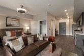 Located at 26000 W Lugonia Ave in Redlands, California, this single-floor residence offers a well-designed open-concept layout with modern finishes throughout. Wood-look plank flooring flows seamlessly across the main living areas, lending warmth and visual continuity to the space.

The kitchen is a functional centerpiece, outfitted with dark espresso cabinetry, light quartz countertops, and a full suite of stainless steel appliances including a gas range, built-in microwave, refrigerator, and dishwasher. A double-basin sink with a modern faucet completes the setup, and the open sightlines connect the kitchen directly to the living area.

The living room is bright and inviting, with large windows and a sliding glass door that opens to a private balcony, bringing in natural light and views of the surrounding landscape. The bedroom is generously proportioned, featuring a reach-in closet, a stylish ceiling fan fixture, and ample room for furnishings. Warm neutral tones and tasteful decor contribute to a comfortable, residential atmosphere.

The bathroom is clean and well-appointed, with a single-sink vanity topped with a quartz-style surface, dark cabinetry, a full soaking tub with shower, and recessed lighting. Overall, the space presents a cohesive modern aesthetic with practical amenities suited for everyday living.
