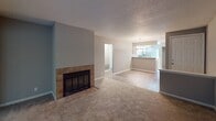 Located at 190 Three Mast Ct in Savannah, Georgia, this single-floor residence offers a well-organized layout with a comfortable blend of functional living spaces. The living area is a standout feature, anchored by a tile-surround fireplace with a classic black iron grate, creating a warm focal point. Plush carpeting flows through the living and bedroom areas, while wood-look vinyl flooring runs through the kitchen and bathrooms, providing a cohesive aesthetic throughout. Large windows in the living area and bedrooms allow natural light to fill each room, with views of the surrounding greenery. The kitchen is equipped with white shaker-style cabinetry, light quartz-style countertops, a stainless steel refrigerator, and an electric range, all complemented by a pass-through peninsula that connects to the dining and living areas. Two full bathrooms are finished with white vanities, wood-look flooring, and tub-shower combinations. The bedrooms each feature generous louvered bi-fold closets and neutral gray walls beneath textured ceilings. The overall ambiance is clean, neutral, and move-in ready, making this Savannah residence a practical and inviting home.