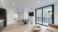 Located in the heart of Midtown Atlanta, this 1-bedroom, 1-bathroom residence offers a thoughtfully designed open-concept layout with contemporary finishes throughout. Light oak hardwood flooring flows seamlessly across the living, dining, and kitchen areas, creating a cohesive and inviting atmosphere.

The combined kitchen and living space serves as the centerpiece of the home. The kitchen features dark charcoal cabinetry extending to the ceiling, stainless steel appliances, a herringbone tile backsplash, and clean white countertops. A smart thermostat is conveniently installed nearby. The living and dining area enjoys abundant natural light through floor-to-ceiling windows and a sliding glass door that opens onto a private balcony, offering sweeping views of the Atlanta skyline.

The bedroom is a calm retreat, featuring large windows framing dynamic city views and warm hardwood flooring. A dedicated closet provides practical storage. The bathroom is finished in neutral tones with large-format tile, a walk-in glass shower with a rainfall showerhead, and black matte fixtures. An in-unit laundry area adds everyday convenience. Hallways connect each space efficiently, rounding out this well-appointed urban residence.