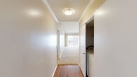 This single-story unit in Slidell, Louisiana offers a practical and functional layout across three bedrooms and two full bathrooms. The living room is a notable highlight, featuring vaulted ceilings with crown molding and a sliding glass door that invites natural light and outdoor views, creating an open, airy atmosphere. Neutral carpet flooring runs throughout the living and bedroom areas, while hardwood flooring defines the kitchen and hallway spaces.

The kitchen is efficiently designed in an L-shaped configuration, equipped with oak cabinetry, granite-style laminate countertops, a double-basin sink, an electric range, and a built-in microwave. A window above the sink provides natural light. The hallway leading to the bedrooms features a textured ceiling, crown molding, and flush-mount lighting, with an in-unit washer and dryer closet conveniently located nearby.

The three bedrooms are carpeted and feature windows with vertical blinds, offering natural light. The primary bedroom includes vaulted ceilings. Both bathrooms are fitted with tub-shower combinations, with one featuring hardwood flooring, warm wood vanity cabinetry, and granite-style countertops. The overall color palette is warm and neutral throughout.