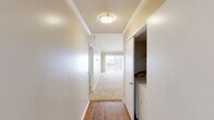 This single-story unit in Slidell, Louisiana offers a practical and functional layout across three bedrooms and two full bathrooms. The living room is a notable highlight, featuring vaulted ceilings with crown molding and a sliding glass door that invites natural light and outdoor views, creating an open, airy atmosphere. Neutral carpet flooring runs throughout the living and bedroom areas, while hardwood flooring defines the kitchen and hallway spaces.

The kitchen is efficiently designed in an L-shaped configuration, equipped with oak cabinetry, granite-style laminate countertops, a double-basin sink, an electric range, and a built-in microwave. A window above the sink provides natural light. The hallway leading to the bedrooms features a textured ceiling, crown molding, and flush-mount lighting, with an in-unit washer and dryer closet conveniently located nearby.

The three bedrooms are carpeted and feature windows with vertical blinds, offering natural light. The primary bedroom includes vaulted ceilings. Both bathrooms are fitted with tub-shower combinations, with one featuring hardwood flooring, warm wood vanity cabinetry, and granite-style countertops. The overall color palette is warm and neutral throughout.