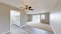 Located at 9440 Clover Avenue in Fountain Valley, CA, this single-floor, one-bedroom, one-bathroom residence offers a practical and comfortable layout. The open-concept living room is carpeted and bathed in natural light through a large sliding glass door fitted with vertical blinds, which also provides access to the outdoors. A wall-mounted air conditioning unit and a ceiling fan with a light fixture keep the space comfortable year-round. The galley-style kitchen is efficiently designed with white cabinetry, granite-look countertops, a stainless steel sink, a gas range with oven, a built-in microwave, and a dishwasher. Recessed lighting illuminates the kitchen, which transitions seamlessly to the living area via an open passageway with light wood-style flooring throughout. The bedroom offers plush carpeting, natural light from a window with vertical blinds, and ample storage with two closets. The bathroom is well-appointed with a tub and shower combination enclosed by sliding glass doors, a white vanity with granite-look countertops, and wood-style flooring. Neutral tones and clean finishes throughout give the space a bright, move-in-ready feel.