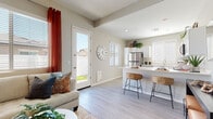 This single-story residence offers a thoughtfully designed open-concept floor plan that seamlessly connects the main living areas. Light-toned luxury vinyl plank flooring runs throughout, lending a clean, cohesive look to the entire space.

The living room is generously proportioned, featuring large windows dressed with horizontal blinds and bold rust-orange curtains that introduce a warm pop of color. The area accommodates a full sectional sofa and flows directly into the dining and kitchen zones, making the layout highly functional and social.

The kitchen is a standout feature, outfitted with crisp white shaker-style cabinetry, light quartz countertops, and a full suite of stainless steel appliances including a refrigerator, range, microwave, and dishwasher. A peninsula with bar seating provides additional prep and dining space, and a window above the sink brings in natural light.

The bedroom is a calm, well-lit retreat with a large window, matching warm-toned curtains, and ample floor space. The bathroom is clean and modern, featuring a white vanity with quartz countertop, light wood-look flooring, a glass-enclosed walk-in shower, and a window for natural ventilation. A private exterior door off the living area provides direct outdoor access, further enhancing the functionality of this well-designed home.