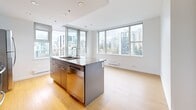Located on the 15th floor at 1051 Broughton Street in Vancouver's West End, this 2-bedroom, 2-bathroom unit offers a well-organized layout with light wood flooring and a clean, modern aesthetic throughout. The open-concept kitchen is a standout feature, equipped with stainless steel appliances including a fridge, stove, and built-in microwave, complemented by granite countertops, a central island with a sink, and sleek cabinetry. Floor-to-ceiling windows flood the living and kitchen area with natural light while framing sweeping panoramic views of the Vancouver skyline and surrounding greenery. Access to a private balcony extends the living space outdoors. Both bedrooms are bright and airy, each featuring large windows with city views and built-in closet storage. The two bathrooms are finished with white subway tile surrounds, soaking tubs with showers, and modern chrome fixtures; one includes large-format floor tiles and a wall-mounted vanity. Connecting the rooms, the hallways are crisp and well-lit with flush ceiling fixtures. The unit's consistent use of light tones, quality finishes, and abundant natural light creates a bright, contemporary living environment in the heart of Vancouver.